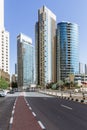 City scape with modern high-rise buildings, road and blue sky in background at Dubai