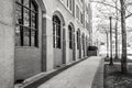 City Sidewalk beside a Brick Building with Arched Windows