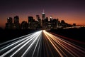 City silhouette with headlamp trails on road captures urban vibrancy