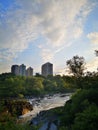 City skyline with a cascading river against a sunset Royalty Free Stock Photo