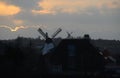 City skyline in evening light with two old windmills Royalty Free Stock Photo