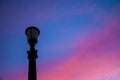 City skyline: the silhouette of an unlit street lamp in the background turning pink sky at dawn Royalty Free Stock Photo