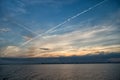 City skyline at sunset sky with plane lines, houses, water Royalty Free Stock Photo