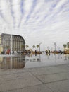 City square with fountains under cloudy sky