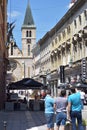 City square with shops, bars and old cathedral clock tower view