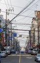 City street with advertising signboards and electric wires in air