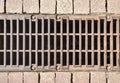 City street brown old rusty metal iron gutter. Gray drain grate for waste and rain water. Street Drainage Sink. Steel Royalty Free Stock Photo
