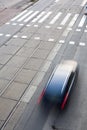 City street with a crossing, rail, motion blurred traffic Royalty Free Stock Photo