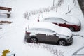 City street driveway parking lot spot with small car covered snow stuck trapped after heavy blizzard snowfall winter day Royalty Free Stock Photo