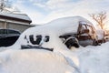 City street driveway parking lot spot with small car covered snow stuck trapped after heavy blizzard snowfall winter day Royalty Free Stock Photo