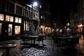 a city street at night with tables and chairs Royalty Free Stock Photo