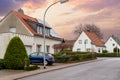 City street single-family modern houses Germany against warm sunset sky. German suburban small town residential area row Royalty Free Stock Photo