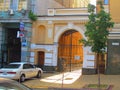 A street in the city of Kiev with a lane to the courtyard decorated with metal gates and a small stone-paved road.
