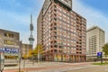 a city street with a tall building and a tower Royalty Free Stock Photo