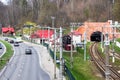 City street with trolleybus line and cars and railway rails going to a tunnel