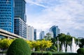 A city with tall office buildings and a central fountain. Sustainable cityscape surrounded by trees and bushes. Sustainable city Royalty Free Stock Photo