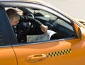 City taxi driver reads a newspaper in the car during the rest