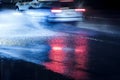 City traffic headlights reflecting in flooded road during rainy Royalty Free Stock Photo