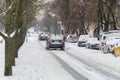 City traffic after heavy snowfall. Cars parked in the snowdrifts and moving cars on the slippery road