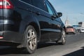 City trafic on the road. Part of black minivan car with selective focus drives on Moscow streets. Side rear low angle view on the Royalty Free Stock Photo