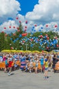 Many people release balls into the sky. Hundreds of multicolored balloons in a blue sky against a background of clouds.