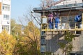 City Tula. Russia - October, 08 , 2021 A mans house painters paint a residential building on a front lift