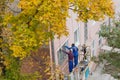 City Tula. Russia - September, 29 , 2021 A mans house painters paint a residential building on a front lift.