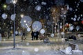 City view, lights, falling snow, night, street, bokeh spots Royalty Free Stock Photo