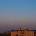 City view moon set in the early morning on a clean gradient sky