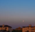 City view moon set in the early morning on a clean gradient sky