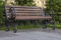 City wooden bench with swirl shape legs on sunny summer day. Copy space