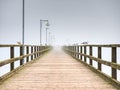 City wooden ocean pier for tourist against misyt sky. Travel destination