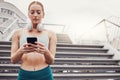 City, workout and woman with smartphone typing, communication, 5g and headphones after exercise. Health, training and