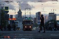 Cityscape. Alley, puddles, clouds, tram, cars, headlights.