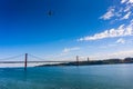 Cityscape with 25 April Bridge over the Tagus river and airplane in Lisbon Royalty Free Stock Photo