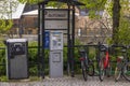 Cityscape background. City car parking equipped with automatic payment machine, garbage container and holders for bicycles.