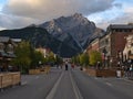 Cityscape of Banff downtown in the Canadian Rocky Mountains with shops and tourists on the street and Cascade Mountain.