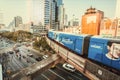 Cityscape with cars and subway train driving under scyskrapers