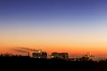 Cityscape with dramatic sky sunset. Silhouette of buildings and smoking pipes. Urban industrial city. Environmental pollution Royalty Free Stock Photo