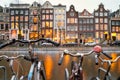 Cityscape - evening view from bicycles to houses with festive decorations and a city channel with boats, city of Amsterdam