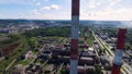 Cityscape with industrial building plant with three tall red and white industrial pipes over clear cloudless blue sky on Royalty Free Stock Photo