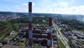 Cityscape with industrial building plant with three tall red and white industrial pipes over clear cloudless blue sky on Royalty Free Stock Photo