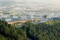 A cityscape of Mansehra city with pine trees and the road curve