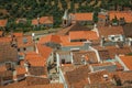 Cityscape with many rooftops, steeple and fields