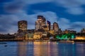 cityscape of a metropolitan area illuminated by the warm lights of the buildings near the waterfront