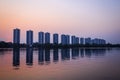 CItyscape modern apartment building near a lake under sunset twilight with cloud sky background with water reflections for Royalty Free Stock Photo