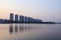 CItyscape modern apartment building near a lake under sunset twilight with cloud sky background with water reflections for Royalty Free Stock Photo