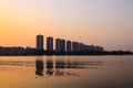 CItyscape modern apartment building near a lake under sunset twilight with cloud sky background with water reflections for Royalty Free Stock Photo