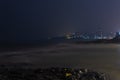 Cityscape at night with beach in the foreground