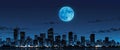 A cityscape at night with a large blue moon in the sky. Royalty Free Stock Photo